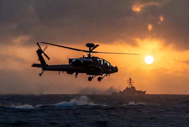 A U.S. Apache attack helicopter in flight over the waters of the Strait of Hormuz.